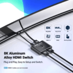 Close-up van de aluminium behuizing in gebruik, met iconen voor 8K 60Hz, 4K 144Hz, HDMI 2.1, Dolby Audio en 3D support.