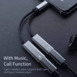 Zilveren USB-C splitter met muziek en bel functie liggend op een tafel