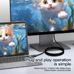 Laptop verbonden met monitor via zwarte kabel, toont katten achtergrond, geen drivers nodig