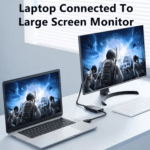 Laptop verbonden met een grote gebogen monitor waarop een shooter game wordt gespeeld