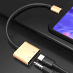 Luxe goudkleurige USB-C dongle voor koptelefoon en oplader op donkere ondergrond