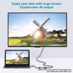 Laptop verbonden met een grote TV via een dongle, toont een helder landschap met windmolen in 4K kwaliteit.
