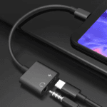 Zwarte USB-C naar aux converter met witte iconen voor audio en stroom