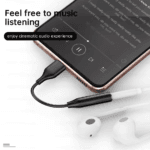 Close-up van telefoon met muziekspeler app verbonden met audio adapter voor bioscoopervaring