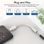 Witte USB-C adapter aangesloten op telefoon met speaker en auto iconen