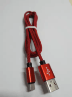Echte foto van de rode gevlochten USB kabel met rode aluminium connectoren, opgerold