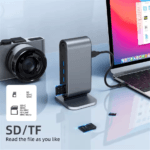 Invoeren van een SD-kaart in de geïntegreerde kaartlezer van een verticale USB-C hub naast een laptop.
