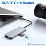 USB-C hub aangesloten op een laptop met SD en TF (MicroSD) kaarten die worden ingevoerd, naast een cameralens