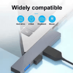 Een grijze USB-hub aangesloten op een laptop, verbonden met een harde schijf, USB-stick, toetsenbord en muis.
