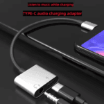 Zilveren USB-C splitter aangesloten op telefoon voor gelijktijdig laden en audio afspelen